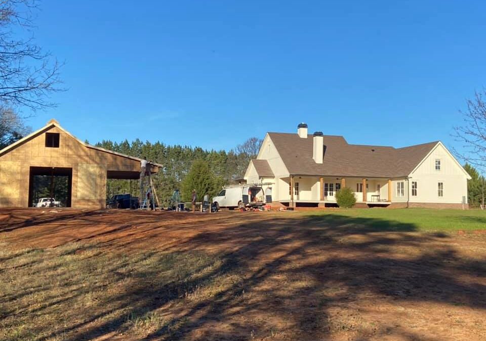 Photo of home under construction along with the matching outbuilding