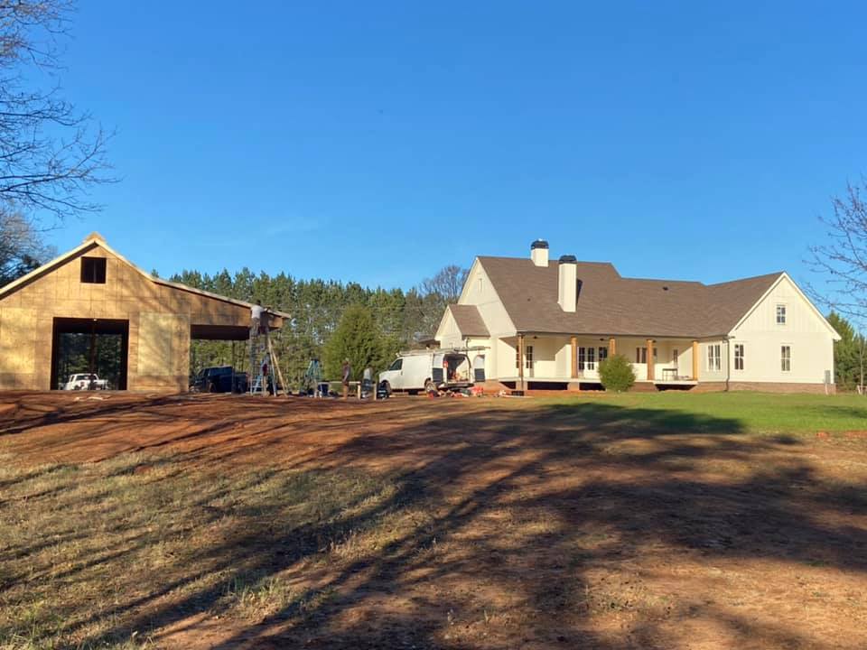 wide view of property of custom outbuillding showing the residence and proximity to custom outbuilding under construction