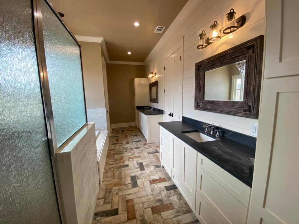 The Boone House in Oconee, GA. Completely customized home. Photo of master bath with double separate sinks, walkin shower and separate soaker tub. Gorgeous tiled floor.