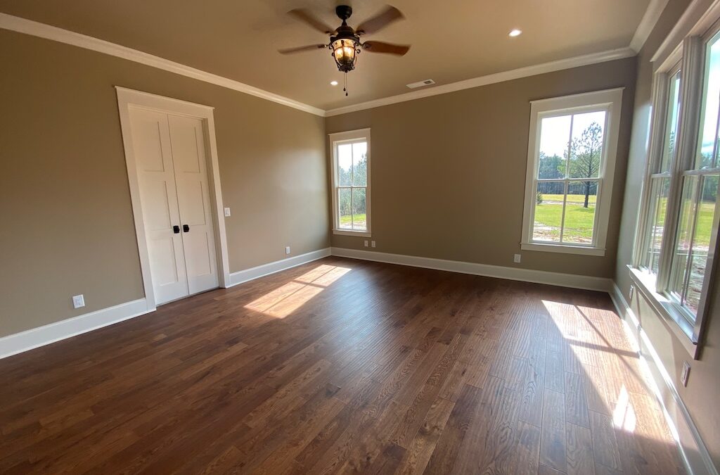 photo of bedroom with wrap around windows and natural light over hardwood floors