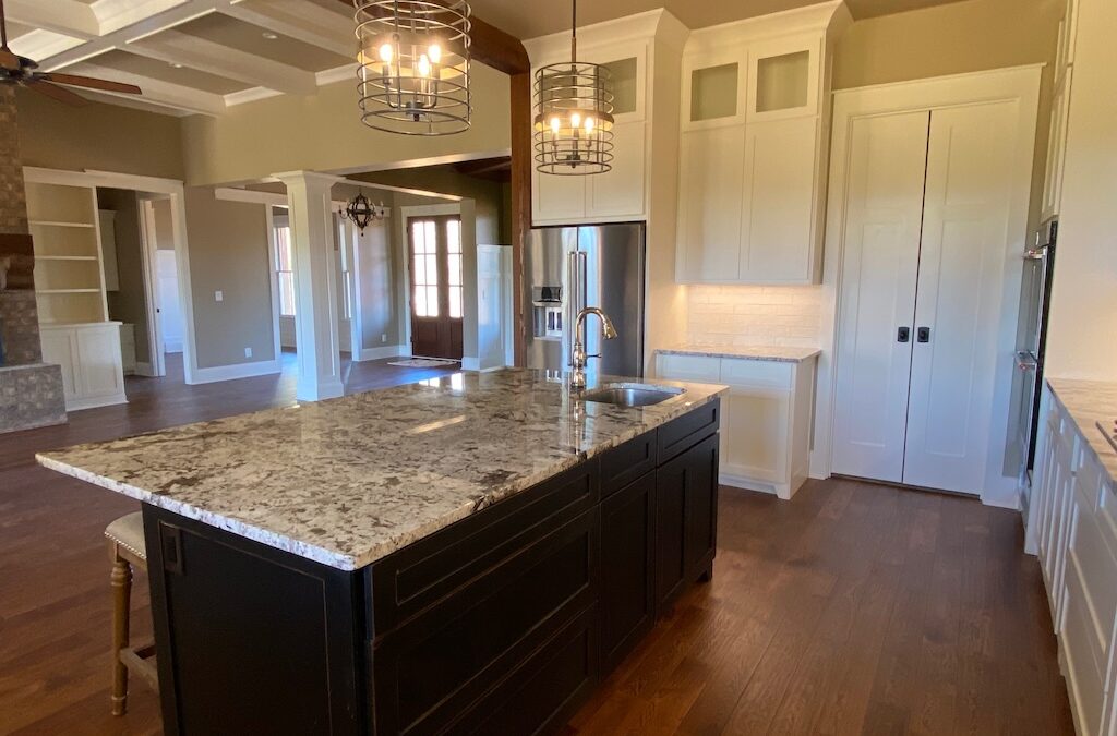 Photo of open kitchen with large eat in island and sliding pantry doors and built in cabinets