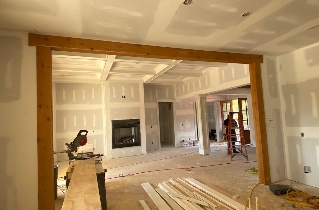 Photo of home under construction taken from dining room to open framing to great room. The fireplace is installed